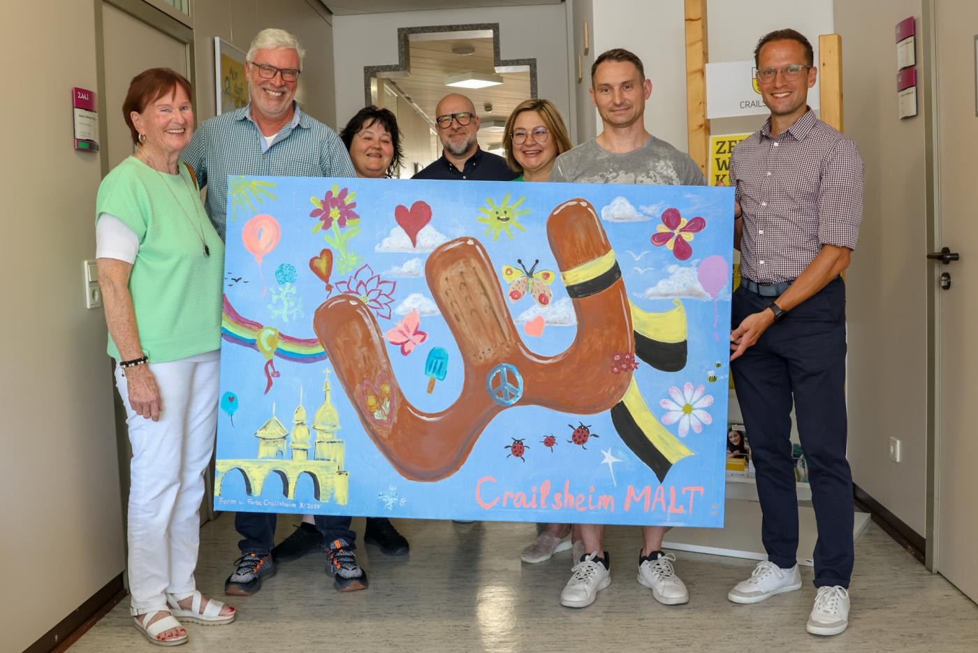 Einige Menschen halten zusammen ein buntes Bild in die Kamera