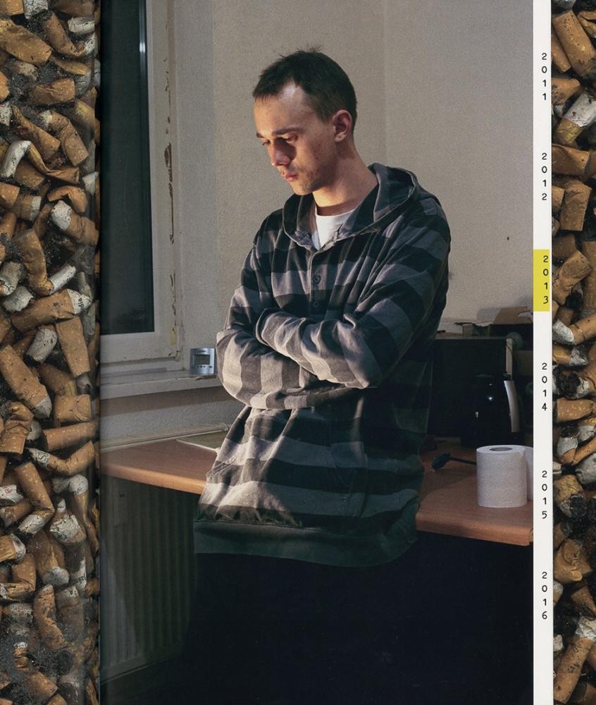 Tino Zimmermann Ein Mann steht nachdenklich an einen Tisch gelehnt