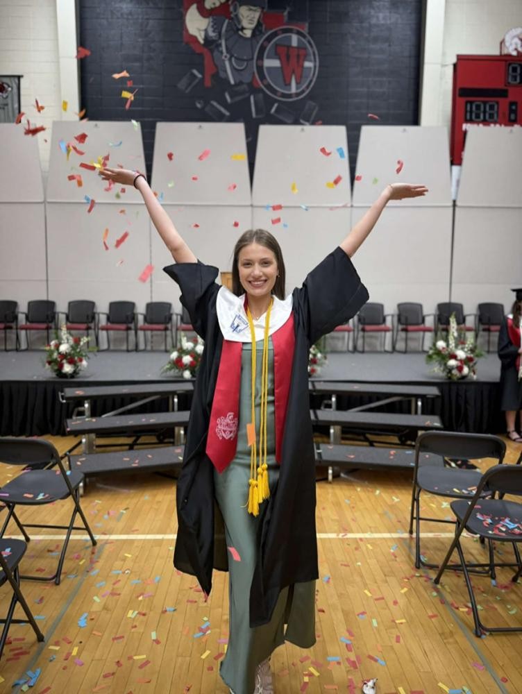 privat Eine junge Frau jubelt im Talar unter einem Konfettiregen