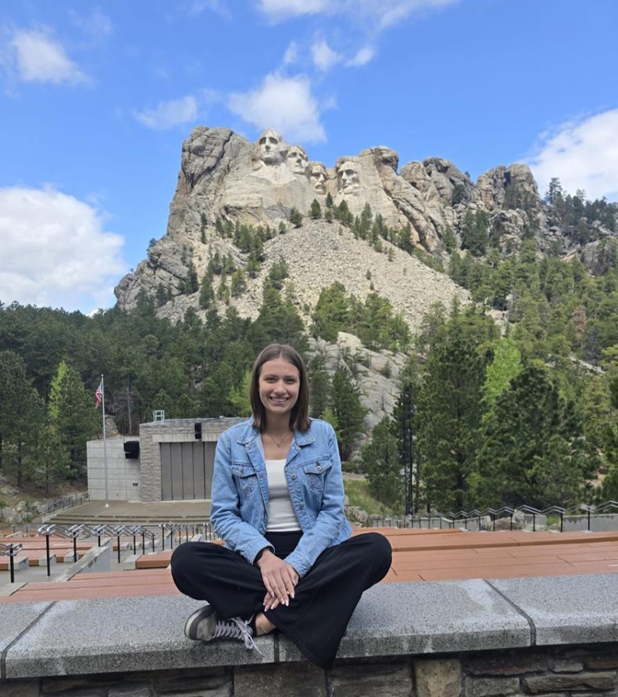 privat Eine junge Frau sitzt lächelnd vor dem Mount Rushmore