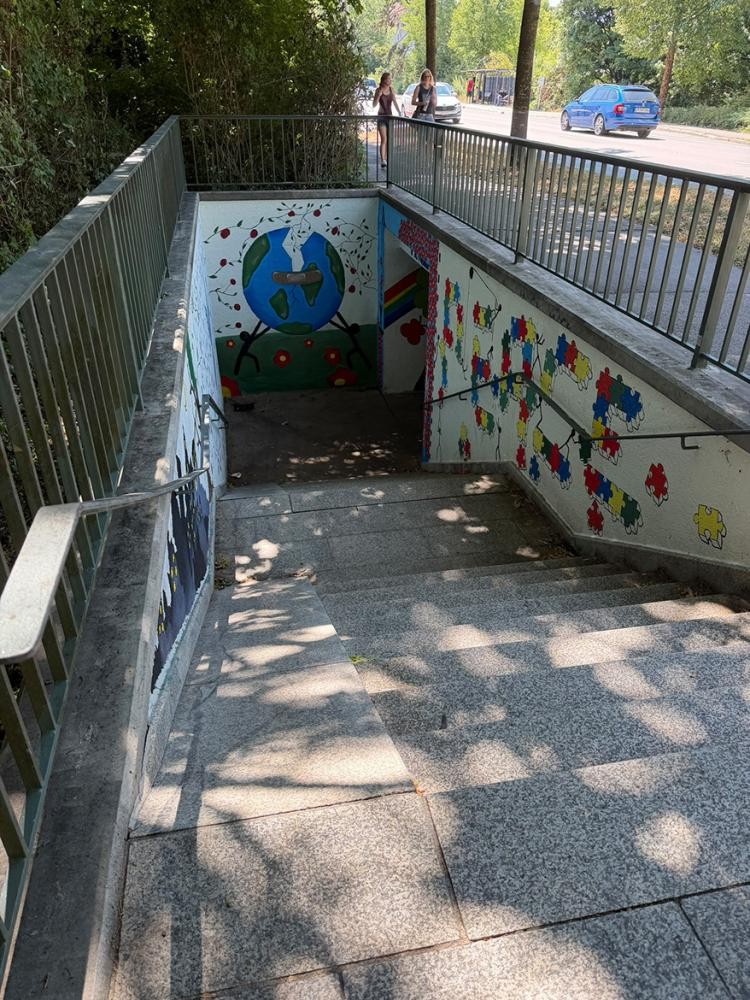 Der Treppenabgang zu einer Unterführung, die mit Graffitis geschmückt ist