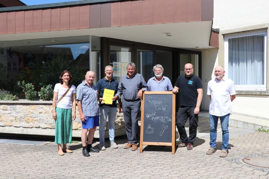 Einige Menschen lächeln bei strahlendem Sonnenschein in die Kamera