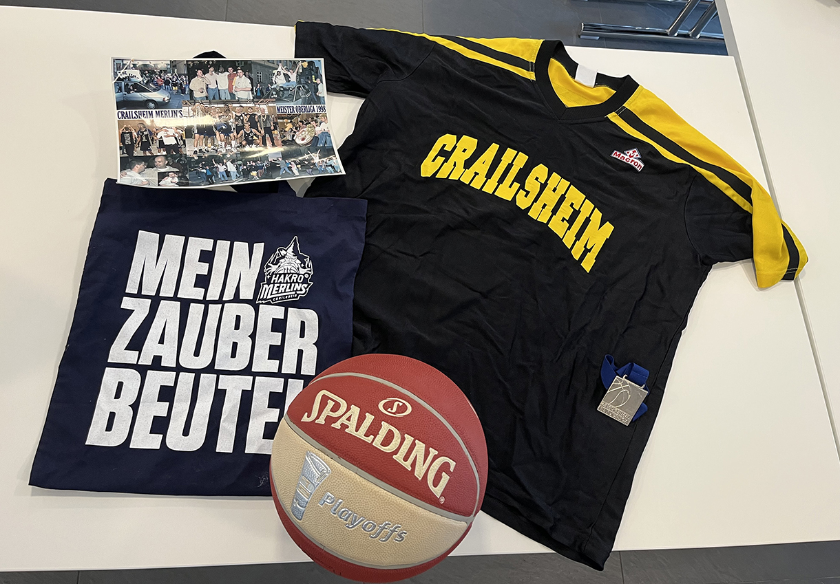 verschiedene Fanartikel wie ein T-Shirt auf einem Tisch