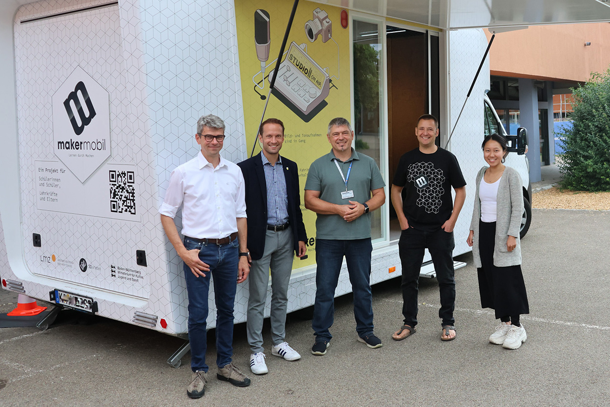 Fünf Personen stehen vor einem geöffneten Mobil