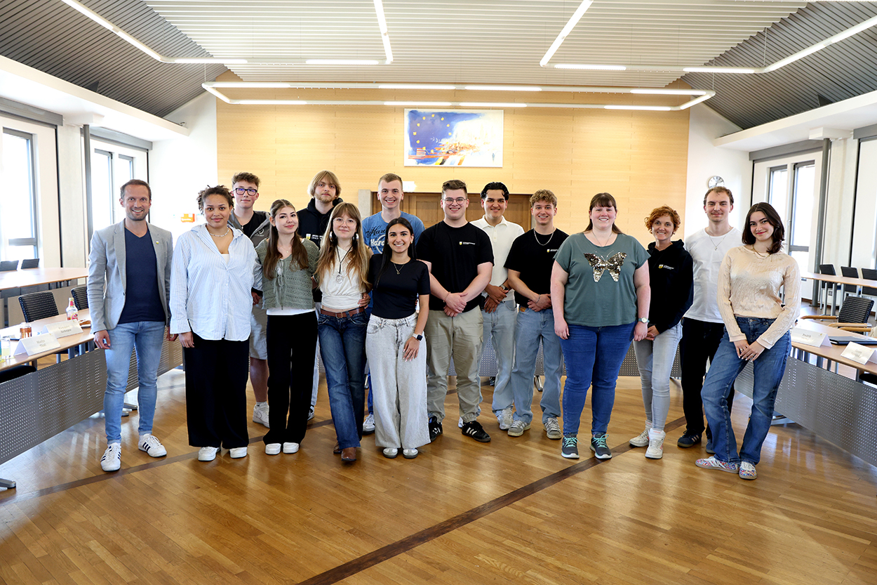 Eine Gruppe junger Menschen und Erwachsener lächelt in die Kamera