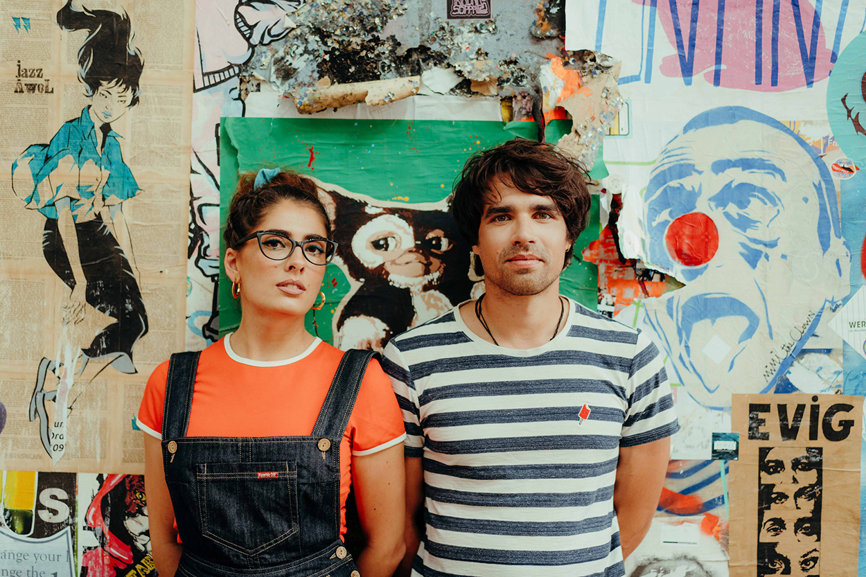 Eine Frau und ein Mann stehen vor einer bunten Wand