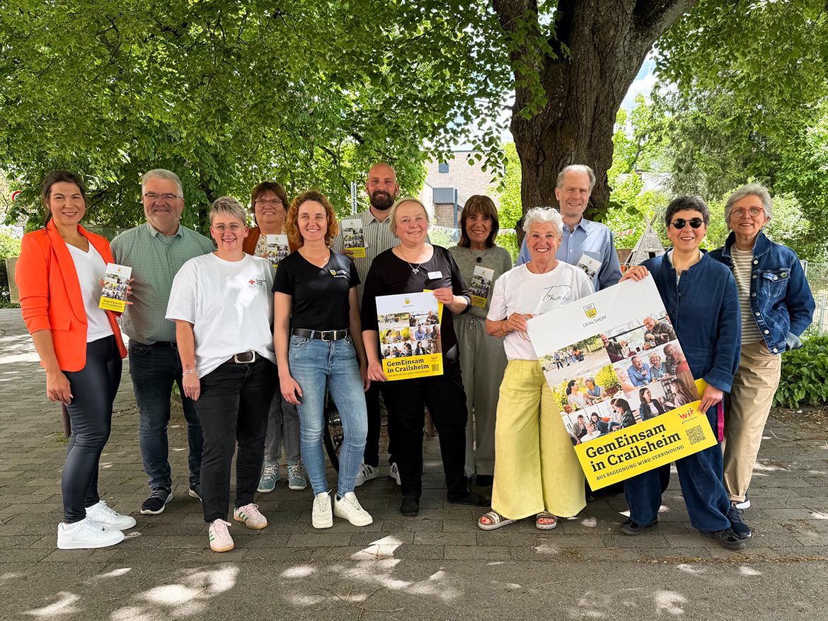 Einge Leute stehen, teils mit Plakaten und Flyern in der Hand, für ein Foto parat