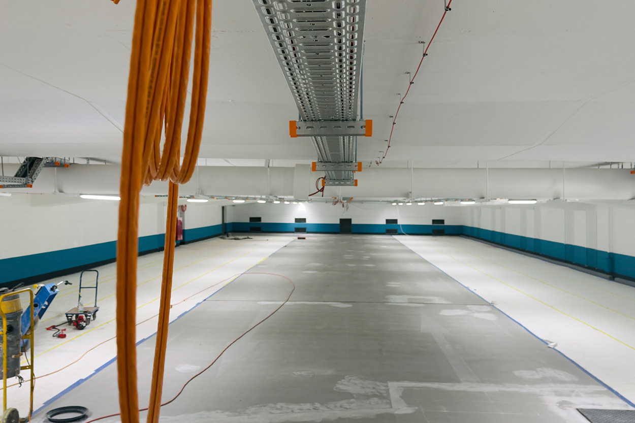 Eine Tiefgaragenebene im Umbau, Kabel hängen von der Decke