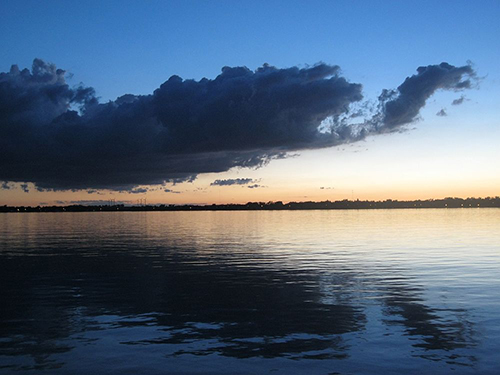 Ein spiegelglatter See mit eine malerischen Wolke darüber