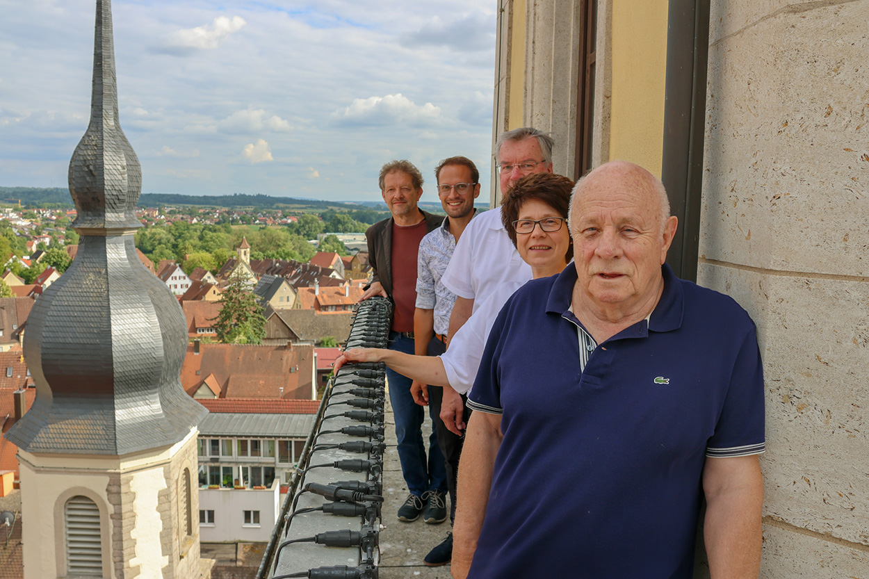 Fünf Personen stehen auf einem Turm und schauen in die Kamera