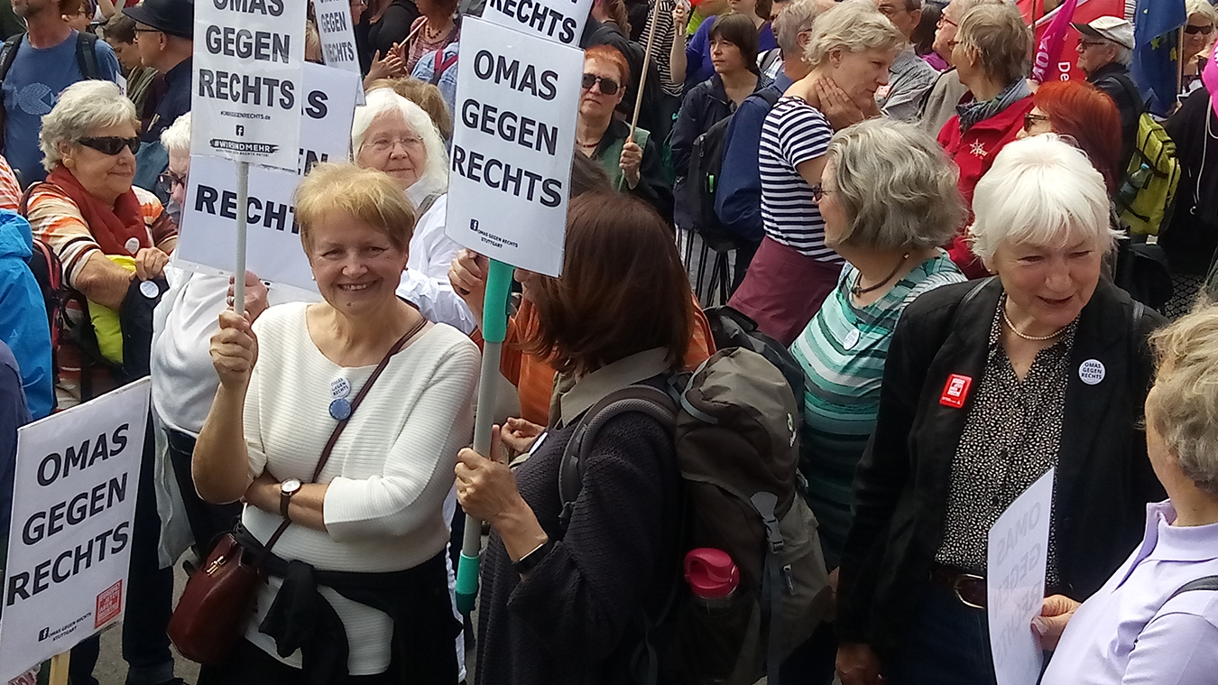 Viele ältere Damen stehen zsuammen udn haben teils Schilder in der Hand