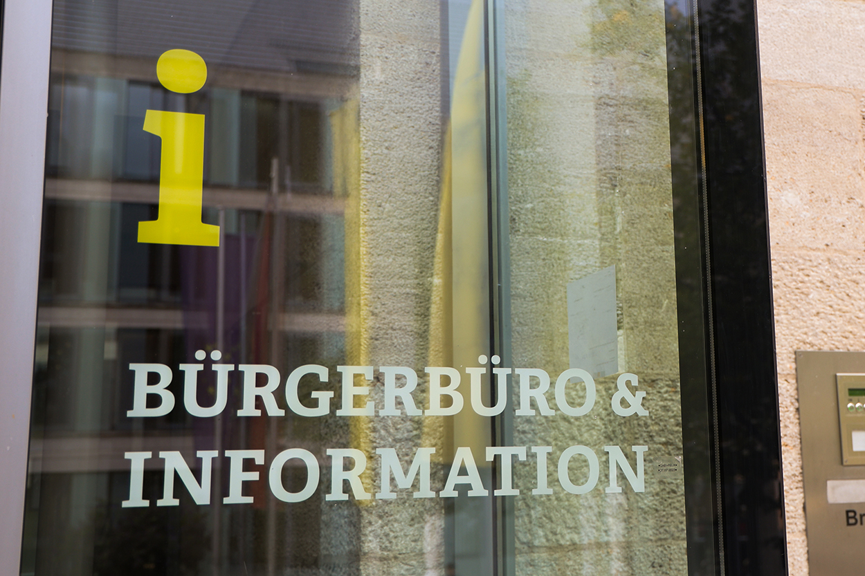 ein großes i auf eienr Glasscheibe mit der Info Bürgerbüro & Information