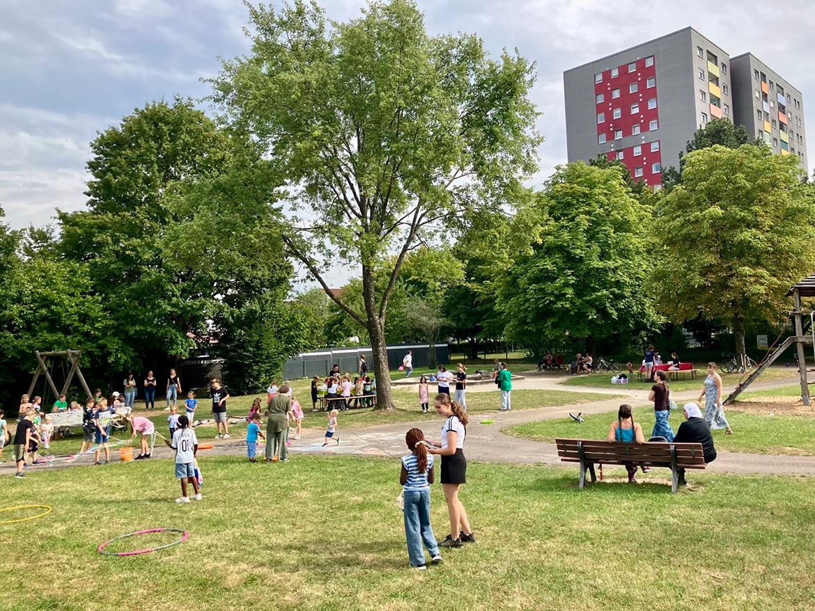 Ein Spielplatzgelände, auf dem viele spielende Kinder zu sehen sind