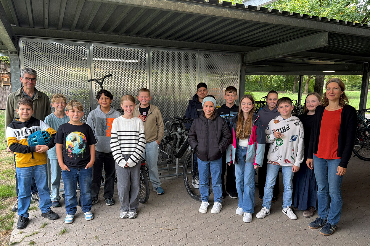 Ein Mann und eine Frau stehen mit Kindern für ein Foto in in einer Fahrradabstellanlage parat