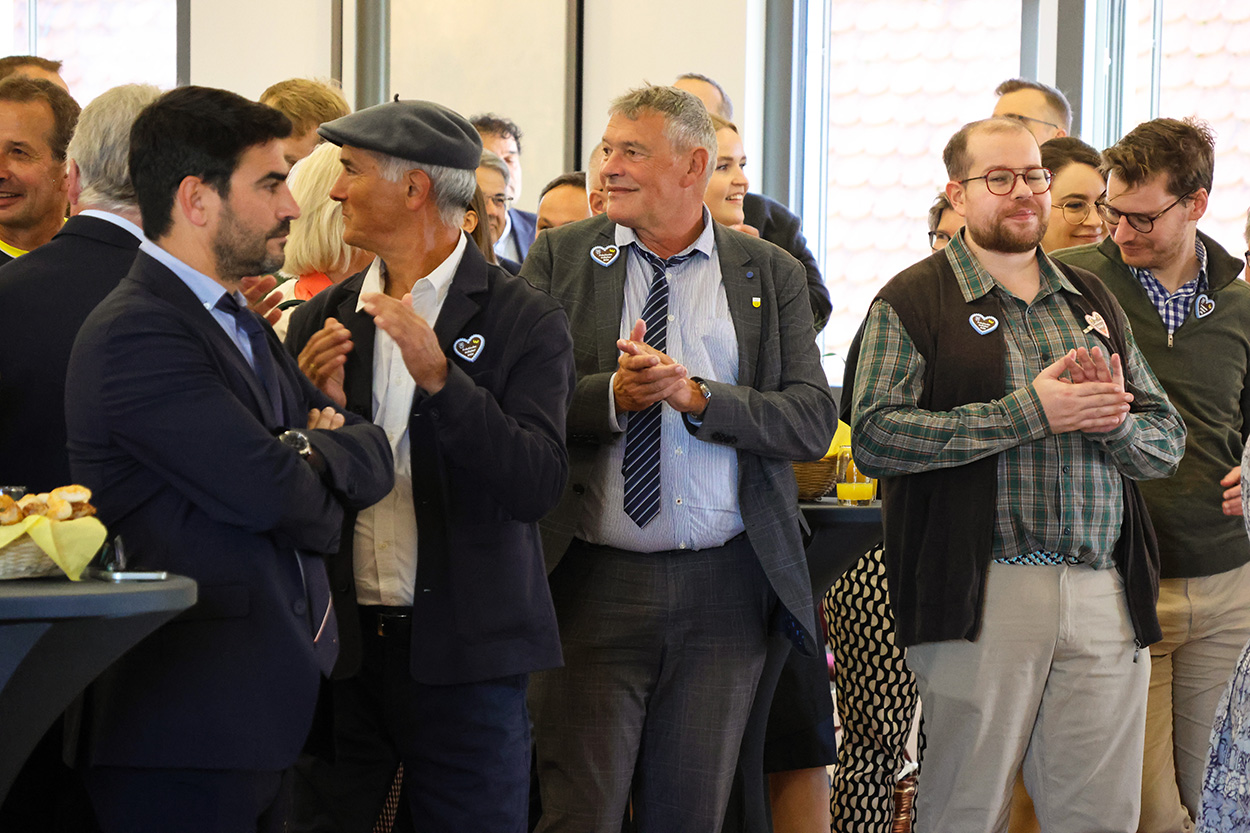 mehrere Menschen stehen in einem Saal