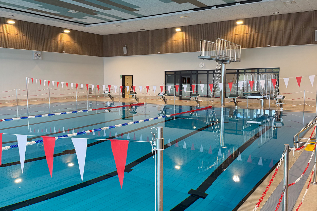 Ein Schwimmbecken in einem Hallenbad mitr rot-weißen Wimpel-Girlanden