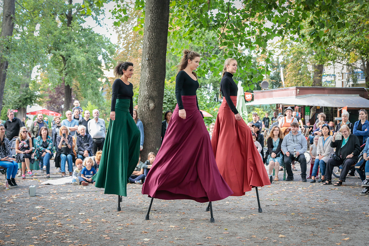 Frauen in altertümlichen Kleider auf Stelzen