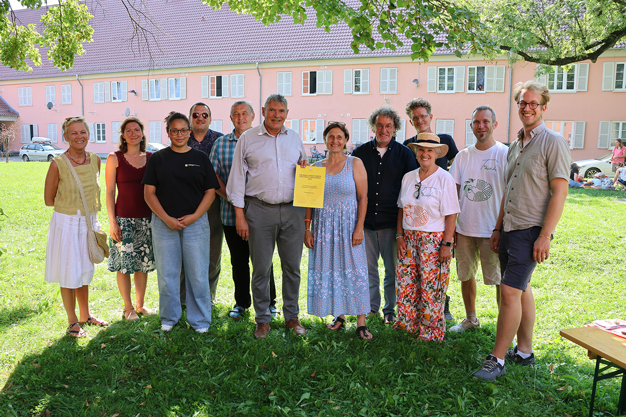 Eine Gruppe von Leuten steht beisammen und lächelt in die Kamera