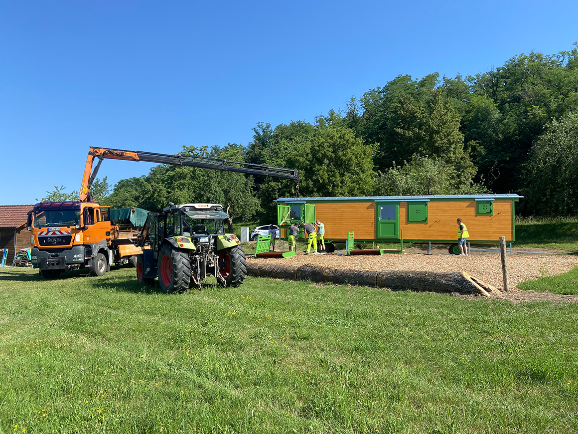 Baumaschinen und einige Männer an Bauwagen