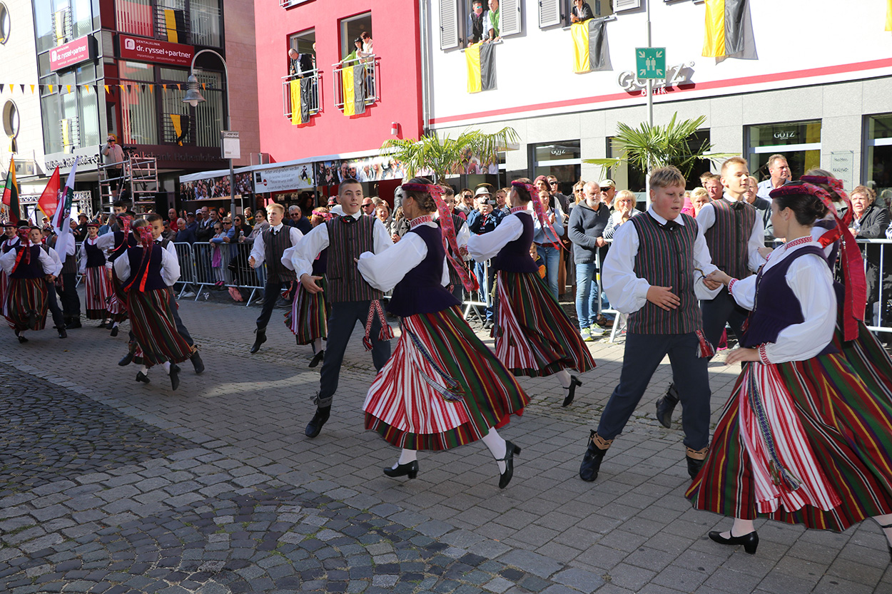 Einige Paare in traditioneller Tracht tanzen auf der Straße