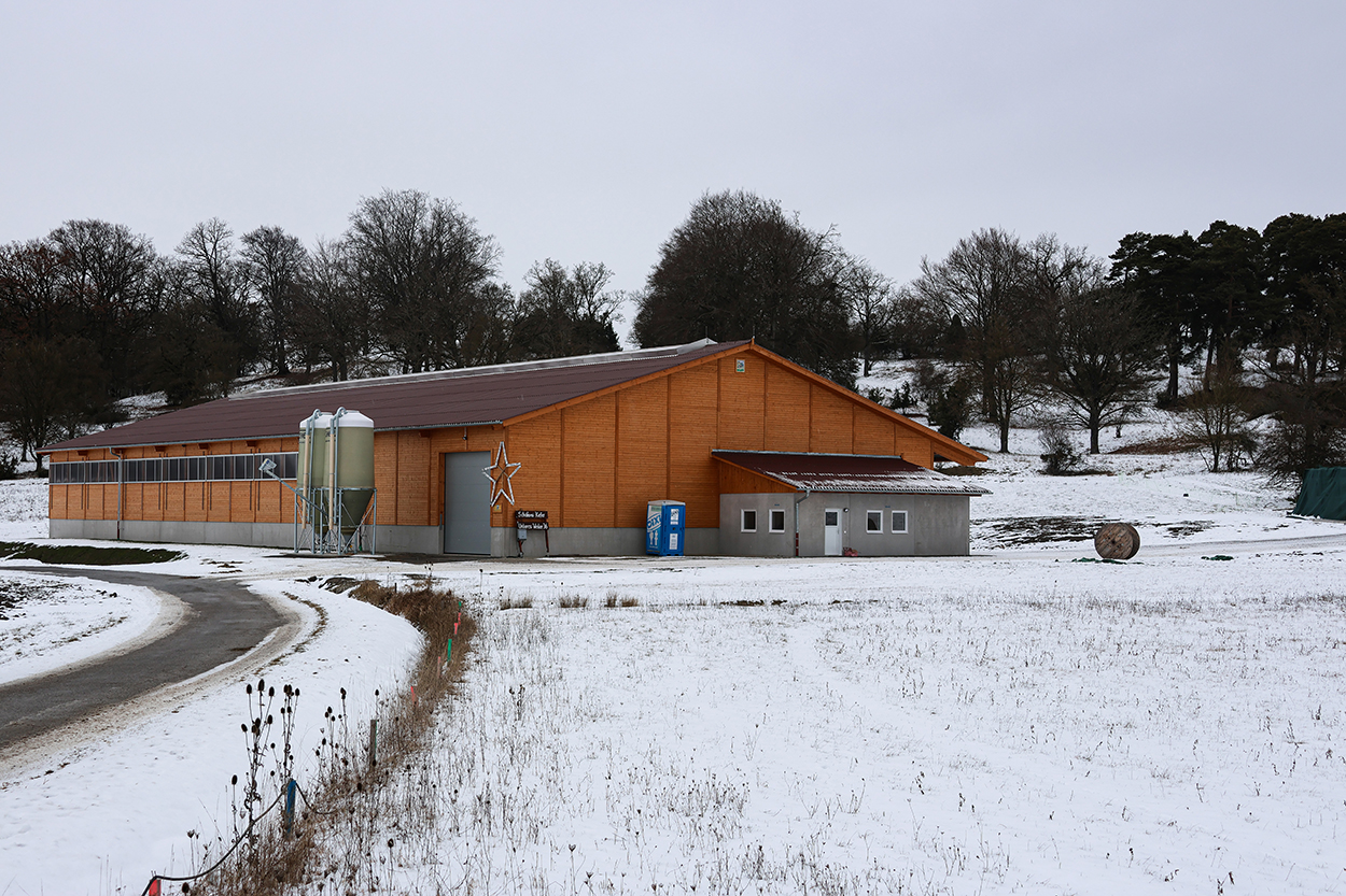 Ein großer moderner Stall in verschneiter Umgebung