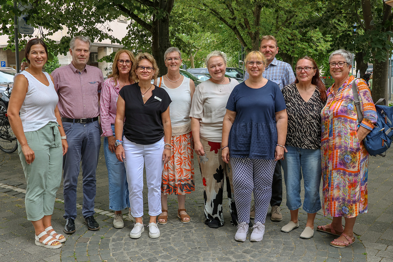 eine Gruppe unterschiedlicher Menschen lacht in die Kamera