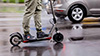 Eine Person auf einem E-Scooter fährt auf einer Straße