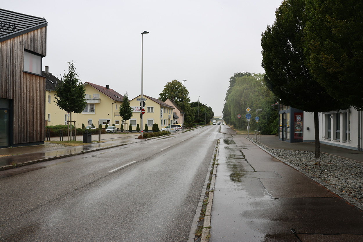Eine regenasse Straße, von Häusern gesäumt