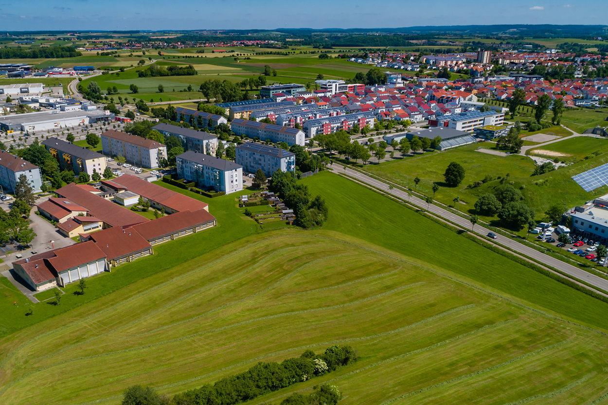 Eine Luftansicht einiger Gebäude und freier Wiese.
