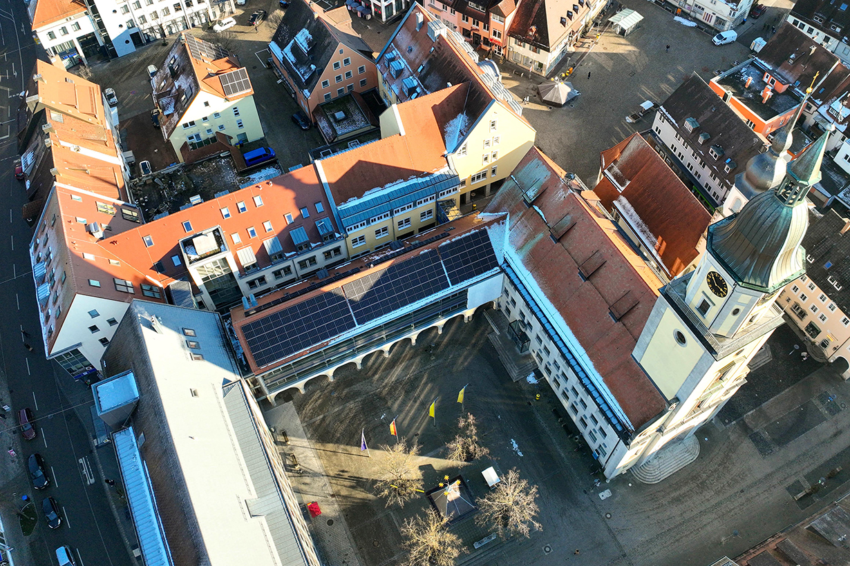 Ein großes Gebäude von oben zus ehen, auf dem Dach eine PV-Anlage